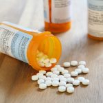 Prescription drug pills spilling from bottle representing medication costs and healthcare policy